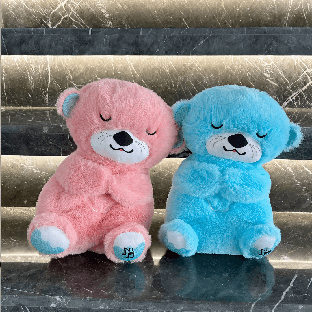 Front view of two Calming Otter dog toys, one pink and one blue, leaning together to show soothing design for easing dog separation anxiety.