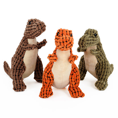 Three Jurassic Chew dinosaur dog toys in orange, green, and brown with a white background. The orange one faces the camera, the green one faces left, and the brown one faces right.